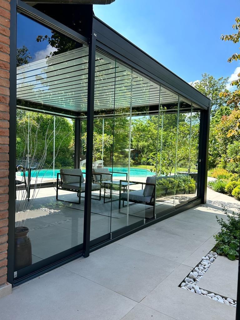 Pergola bioclimatica con vetrate scorrevoli, accanto alla piscina